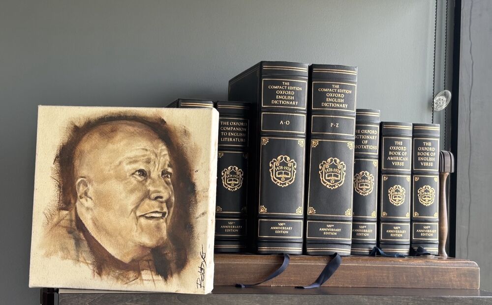 A portrait of John alongside Oxford reference books